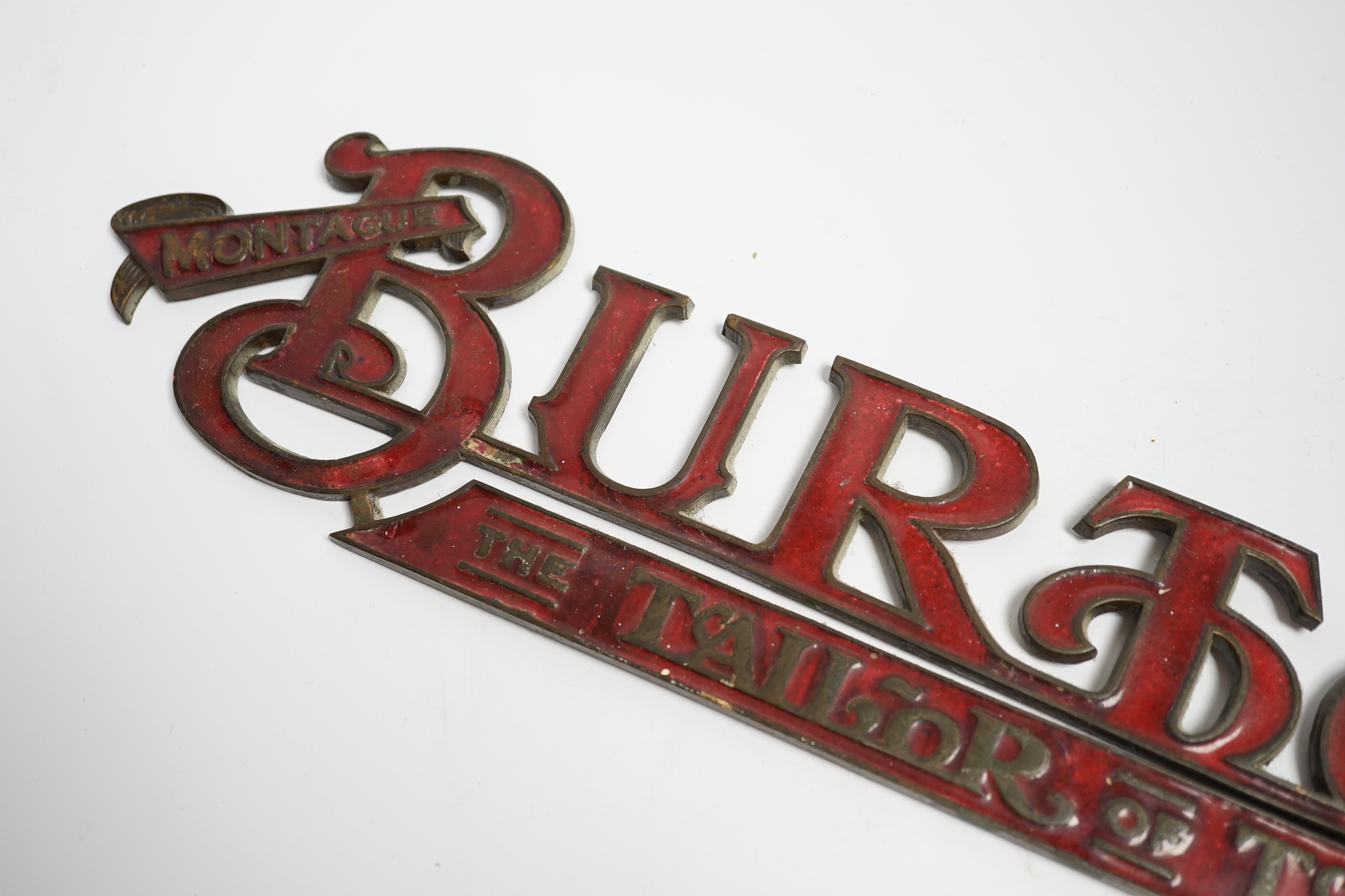 An enamelled bronze 'Montague Burton The Tailor of Taste' shop sign, 41cm wide